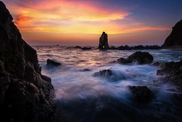Sea wave hit the rock at sunset in Pattaya