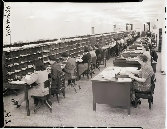 Framed Print : Seated Clerks Look Through and Sort Mail Framed Print : Seated Clerks Look Through and Sort Mail