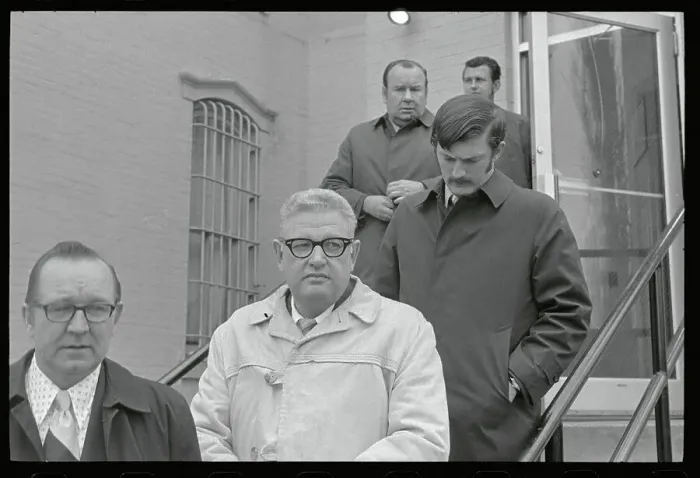 Framed Print : Security Men Escorting a Murder Suspect Framed Print : Security Men Escorting a Murder Suspect