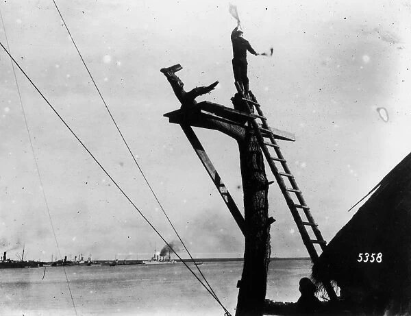 Semaphore. A German sailor signals by semaphore for ships landing at Osel, Russia