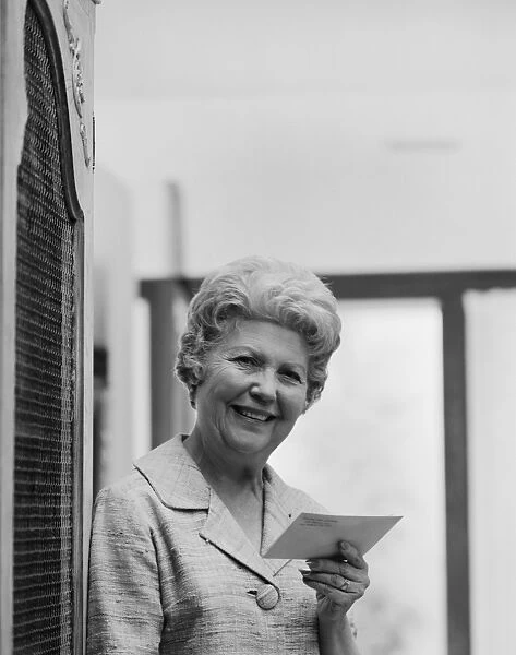 Senior woman holding letter, smiling, portrait