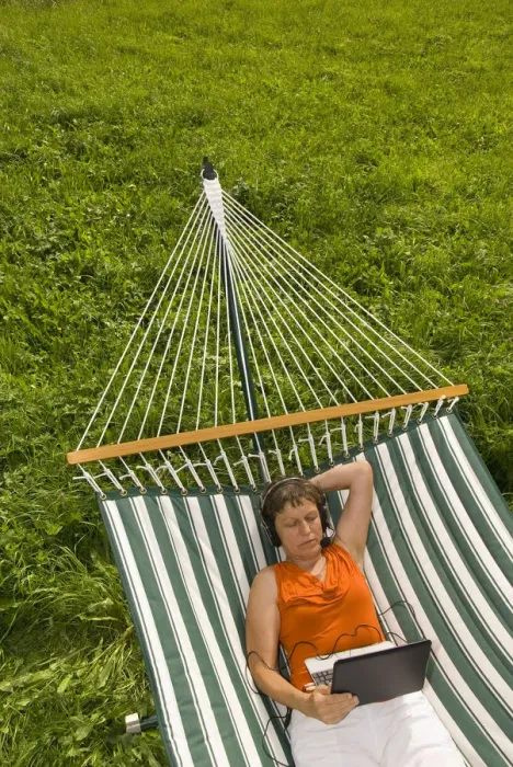 Framed Print : Senior woman with netbook and headset lying in a hammock Framed Print : Senior woman with netbook and headset lying in a hammock