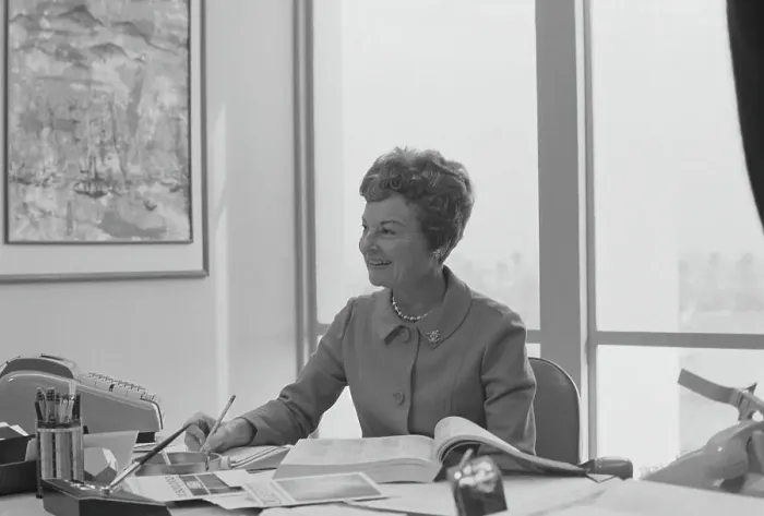 Framed Print : Senior woman sitting at desk writing on notepad, smiling Framed Print : Senior woman sitting at desk writing on notepad, smiling