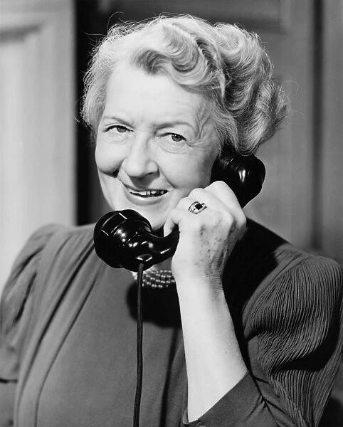 Senior woman talking on telephone, (B&W)