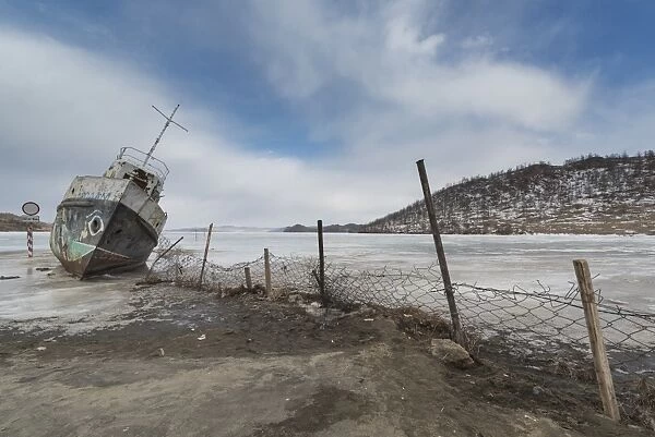 a ship wreck stuck at the frozen ice shore