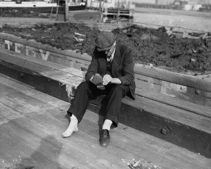 Framed Print : One Shoe. A man in a suit sits down to take off his shoe, circa 1935 Framed Print : One Shoe. A man in a suit sits down to take off his shoe, circa 1935