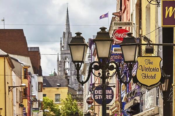 Signs and lights in a street scene in downtown Cork, with Holy Trinity Church in the background, Ireland