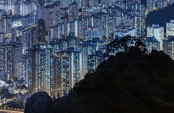 Silhouette of mountain over illuminated Hong Kong