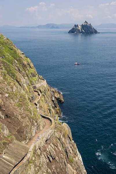 Skellig Michael (Great Skellig), Skellig islands, County Kerry, Munster province, Ireland, Europe. The trail on the cliff with the little Skellig on the background