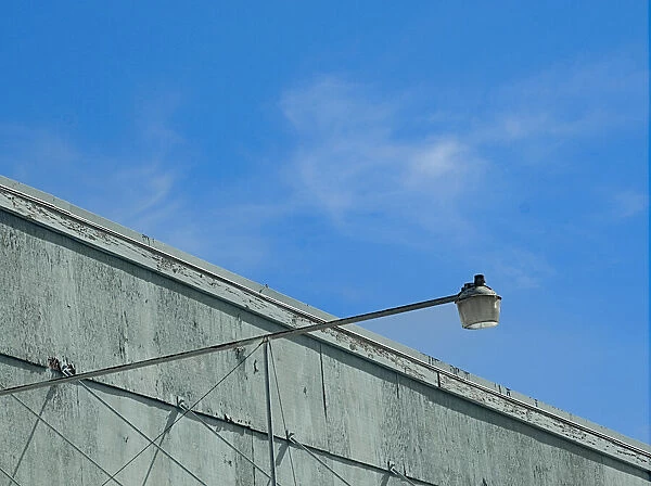 Sky Light. A color photo of a security light on an aging commercial building in Portland