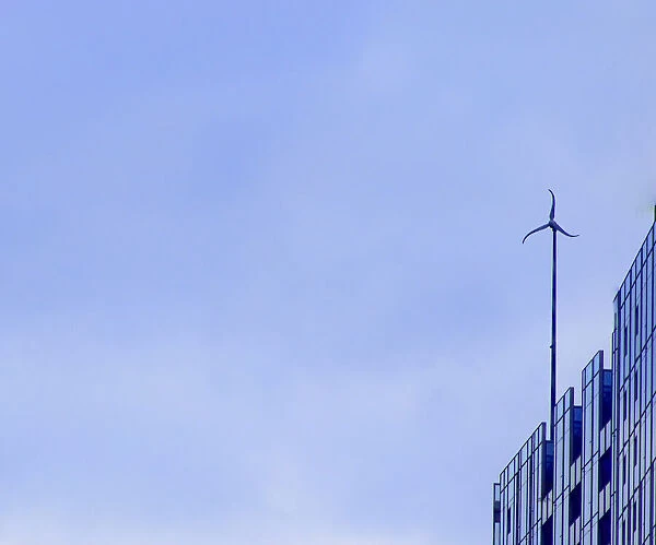 Sky Wheel. A color photo of a wind turbine on the roof of a skyscraper