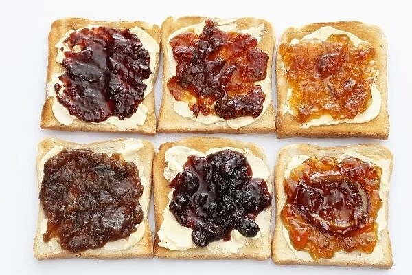 Six slices of toast with various jams, rhubarb jam, apricot jam, strawberry jam, orange marmalade, cherry jam and ginger marmalade