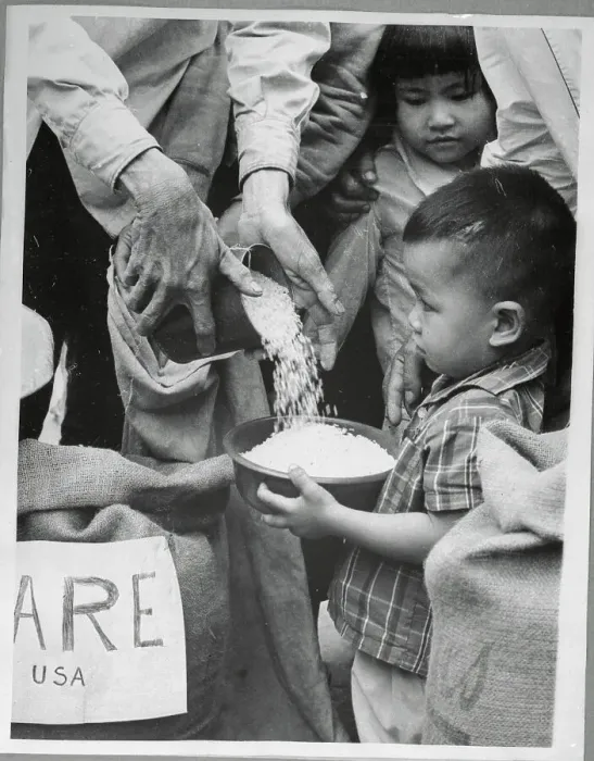 Framed Print : Small Child Receiving Food Rations in Saigon Framed Print : Small Child Receiving Food Rations in Saigon