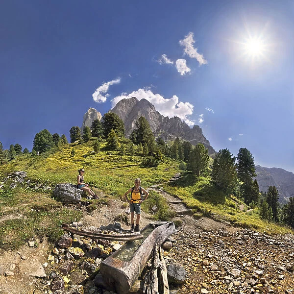 Small spring at Mt Peitlerkofel, Sasso delle Putia, with hiker at Wuerzjoch, Passo delle Erbe, Villnoess, Funes, Dolomites, South Tyrol, Italy, Europe