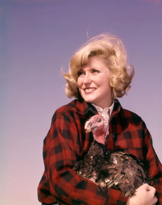 Framed Print : Smiling blonde woman holding thanksgiving turkey Framed Print : Smiling blonde woman holding thanksgiving turkey