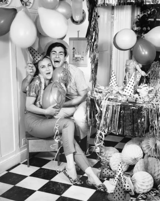 Framed Print : Smiling couple sitting in kitchen amongst party preparations, (B&W), portrait Framed Print : Smiling couple sitting in kitchen amongst party preparations, (B&W), portrait