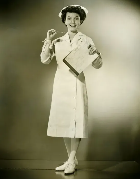 Framed Print : Smiling nurse holding thermometer and files in studio, (B&W), portrait Framed Print : Smiling nurse holding thermometer and files in studio, (B&W), portrait