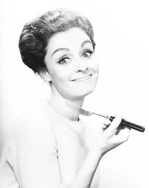 Smiling woman holding fork, (B&W), close-up