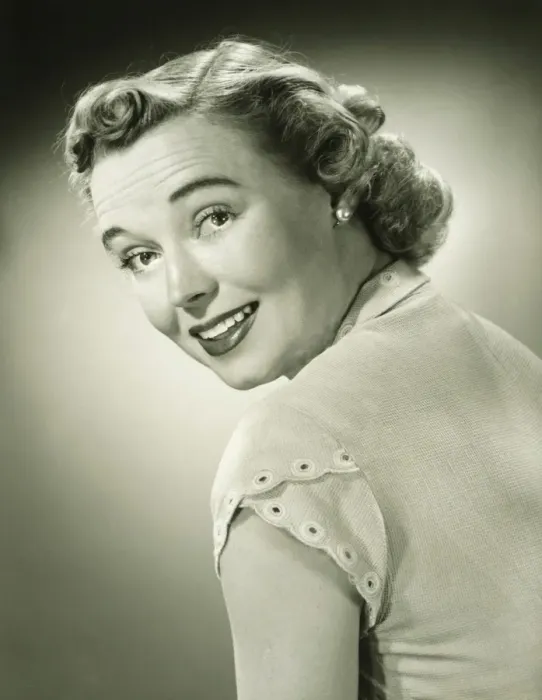 Framed Print : Smiling woman looking over shoulder in studio, (B&W), portrait Framed Print : Smiling woman looking over shoulder in studio, (B&W), portrait