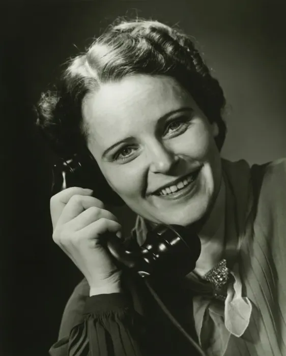 Framed Print : Smiling woman on phone posing in studio, (B&W), close-up, portrait Framed Print : Smiling woman on phone posing in studio, (B&W), close-up, portrait
