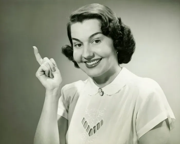 Framed Print : Smiling woman pointing finger in studio, (B&W), (Close-up), (Portrait)