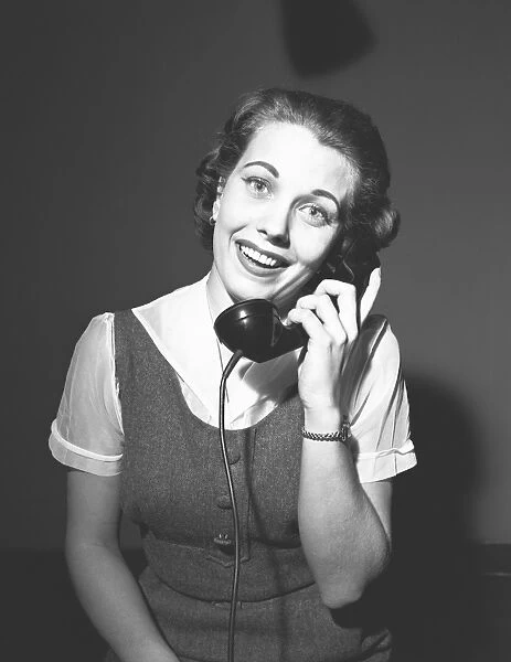 Smiling woman talking on phone, (B&W), portrait