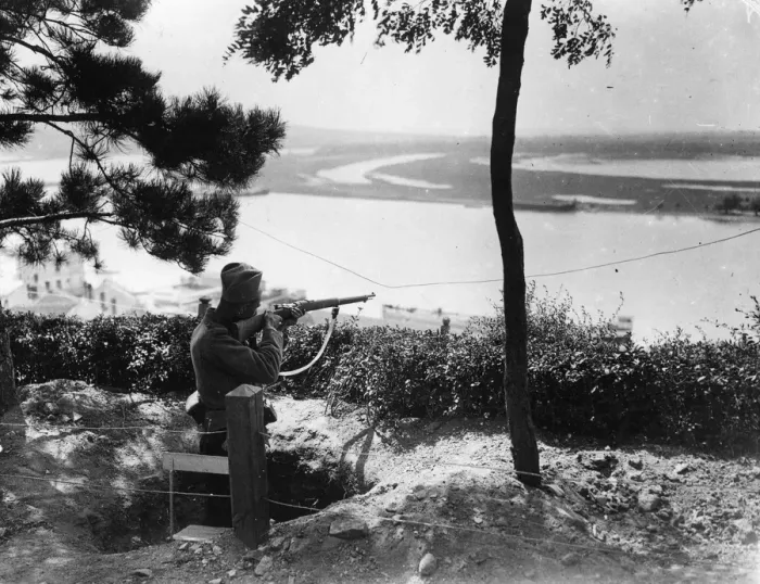 Framed Print : A Sniper. circa 1916: A sharpshooter aims over a river from high ground in Serbia