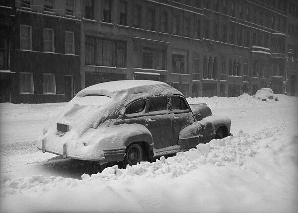 Snow capped car on street, (B&W)