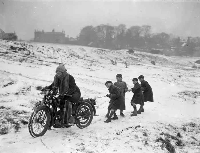Framed Print : Snow Ride. January 1926: Youngsters being pulled along by a girl on a motorbike Framed Print : Snow Ride. January 1926: Youngsters being pulled along by a girl on a motorbike