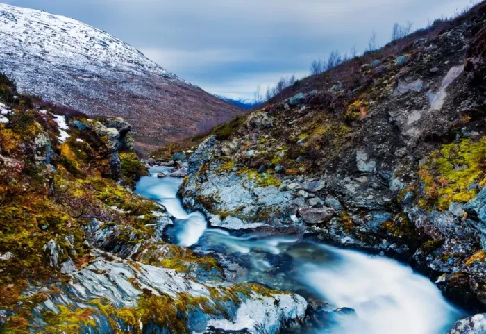 Framed Print : Snow thaw. Stream winds itself down mountain pass at top of snow road in Norway Framed Print : Snow thaw. Stream winds itself down mountain pass at top of snow road in Norway
