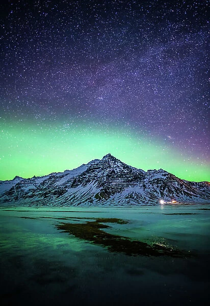 Snowy mountain with the aurora and milky way in Southern Iceland