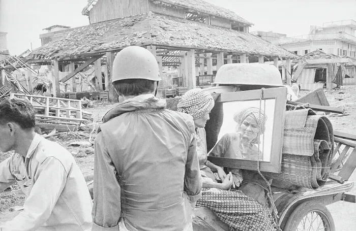 Framed Print : Soldier Gazing at Woman Exiting War Torn Town with Possessions Framed Print : Soldier Gazing at Woman Exiting War Torn Town with Possessions
