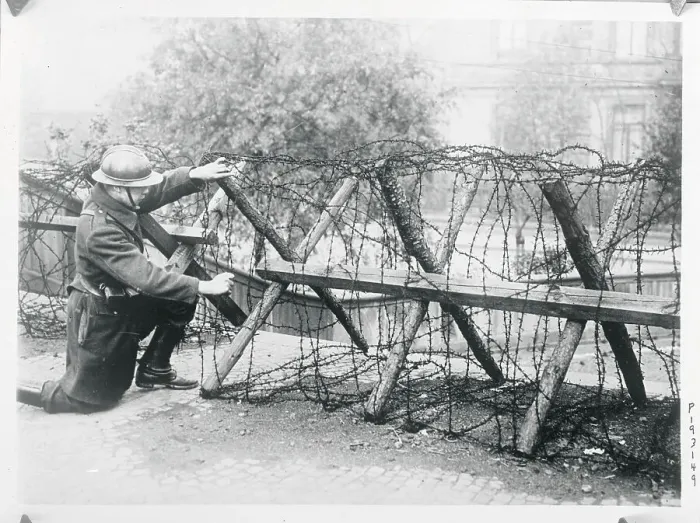 Framed Print : Soldier Stooping to Work on Fence Framed Print : Soldier Stooping to Work on Fence