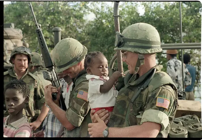 Framed Print : Soldiers Play with Baby While Holding Guns Framed Print : Soldiers Play with Baby While Holding Guns