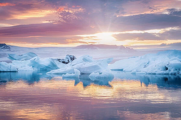 South Iceland, Jokulsarlon, Ice on the lagoon reflecting the colours of sunset