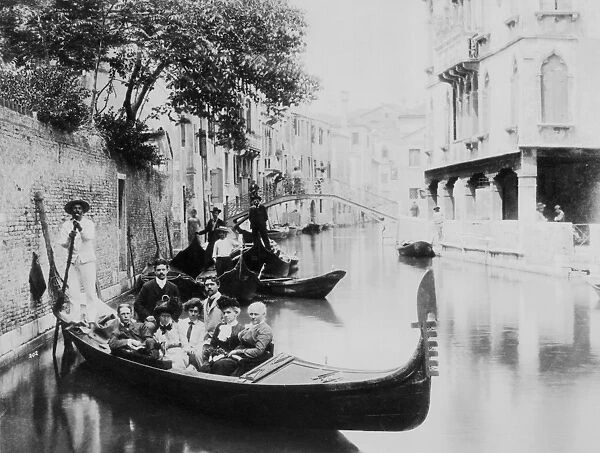Souvenir Of Venice. A group of tourists posing on a gondola on a canal in Venice
