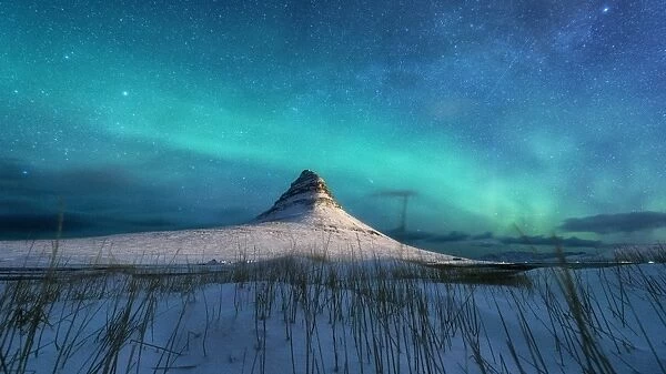 Spectacular northern lights appear over Mount Kirkjufell and waterfall in Iceland