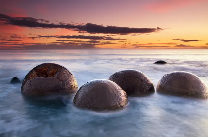 Framed Print : Spherical boulders in the sea at sunrise