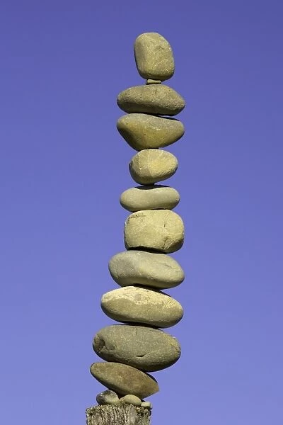 Stack of stones on fence post, low angle view