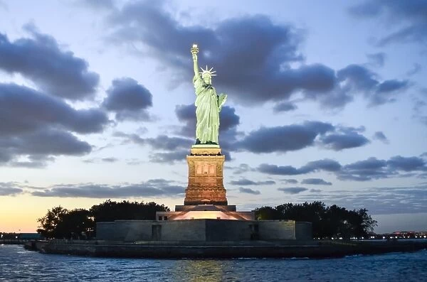 Statue of Liberty illuminated at dusk in New York