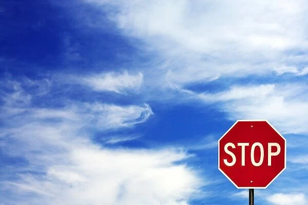 Stop sign. Red stop sign against blue sky with clouds