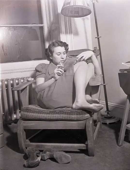 Framed Print : Store Clerk Curled Up Reading in Chair Framed Print : Store Clerk Curled Up Reading in Chair