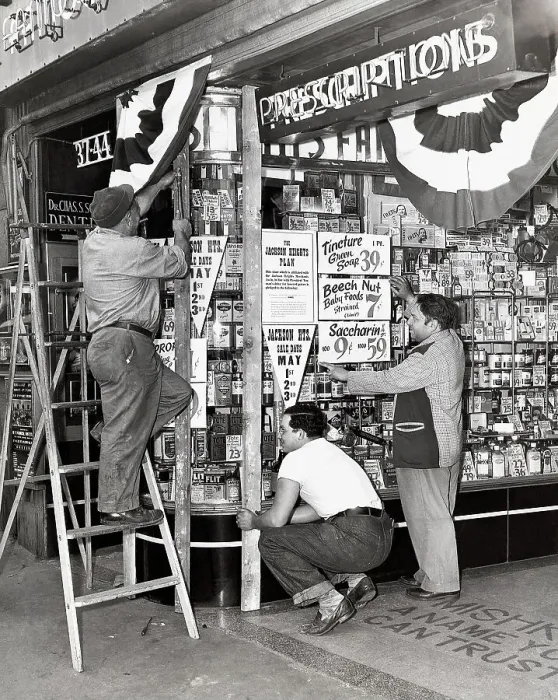 Framed Print : Store Owner Preparing Window for a Sale
