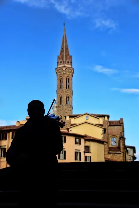 Framed Print : Street musician plays a violin in front of Badia Fiorentina bell-tower in Florence, Italy