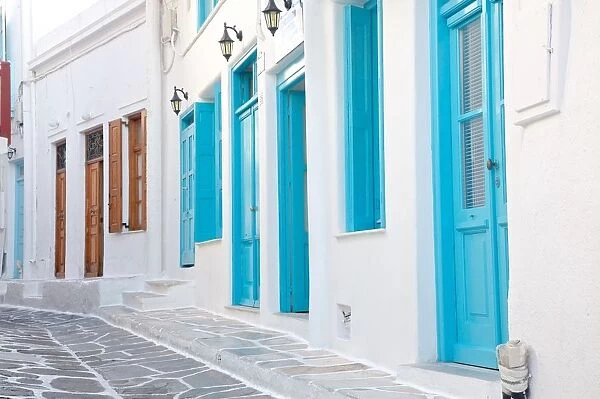 Street with white houses in Mykonos town, Greece