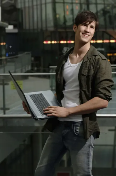 Framed Print : Student holding a laptop computer, smiling Framed Print : Student holding a laptop computer, smiling