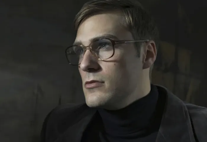Framed Print : Student wearing a suit and glasses, sitting in front of a painting Framed Print : Student wearing a suit and glasses, sitting in front of a painting