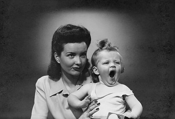 Studio shot of woman with yawning baby girl (6-11 months)