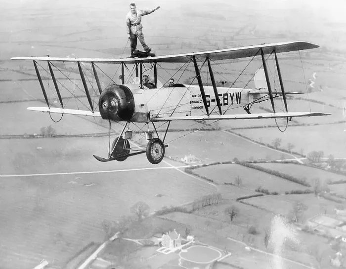 Framed Print : Stunt Flyer on Top of Plane in Midair Framed Print : Stunt Flyer on Top of Plane in Midair