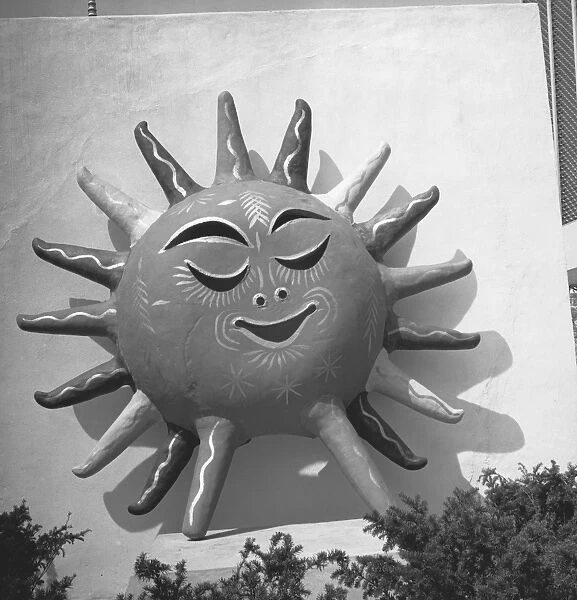 Sun with human face on building wall, (B&W)